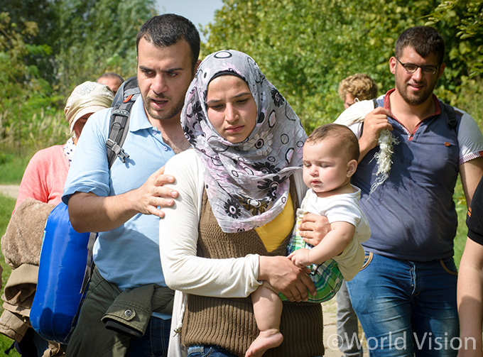 월드비전 직원과 함께 난민캠프로 이동중인 한 난민 가정과 8개월된 아기